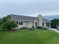 Mid-class home with new gray shingles installed on its roof